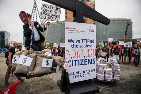 Unterschriftenbündel der Stop-TTIP-Initiative werden bei einer Aktion vor dem Berlaymont-Gebäude in Brüssel gegen Konzerninteressen "abgewogen"