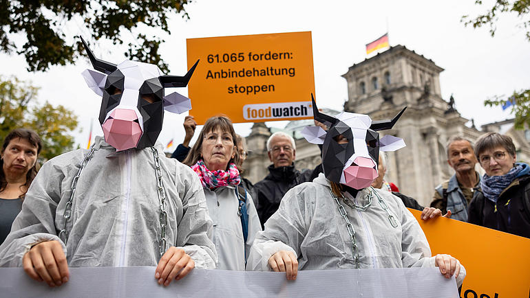„Beendet die Kettenqual!“ – foodwatch-Aktivist:innen und Verbraucher:innen protestieren vor dem Bundestag gegen die Anbindehaltung von Kühen und Rindern. (Foto: foodwatch/Jörg Farys)