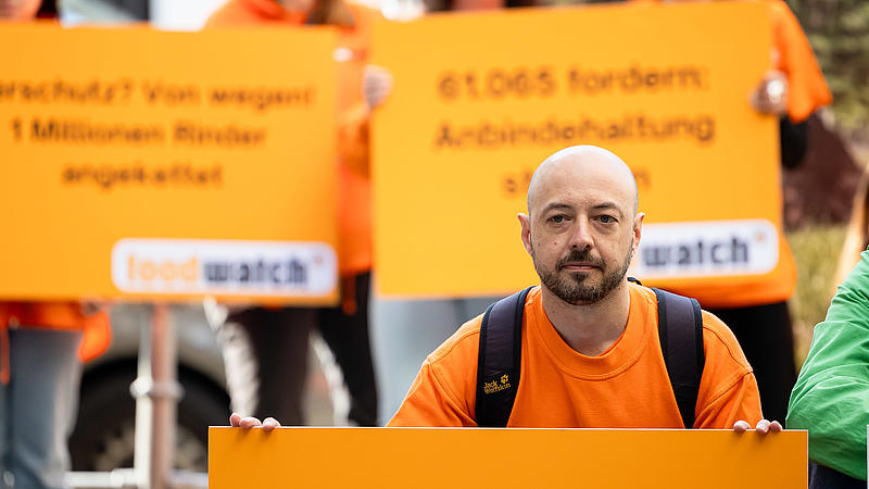 Ein Aktivist mit Schild im Vordergrund und mehrere Aktivisten im Hintergrund