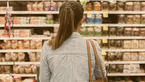 Frau steht vor Supermarkt-Regal